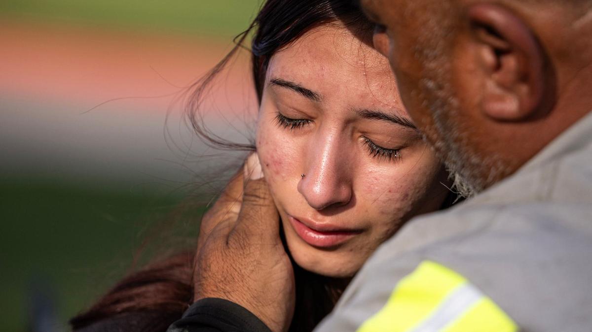 Freshman Amiah Barrera, 15, is comforted by her grandfather after April 24, 2024 shooting at Bowie High School in Arlington, Texas.