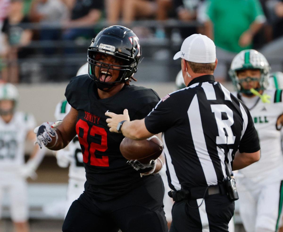 A Trinity defender hands a recovered football to the referee during a UIL 6A Conference football game at Pennington Field in Bedford Texas, Friday, Sept. 20, 2024.
