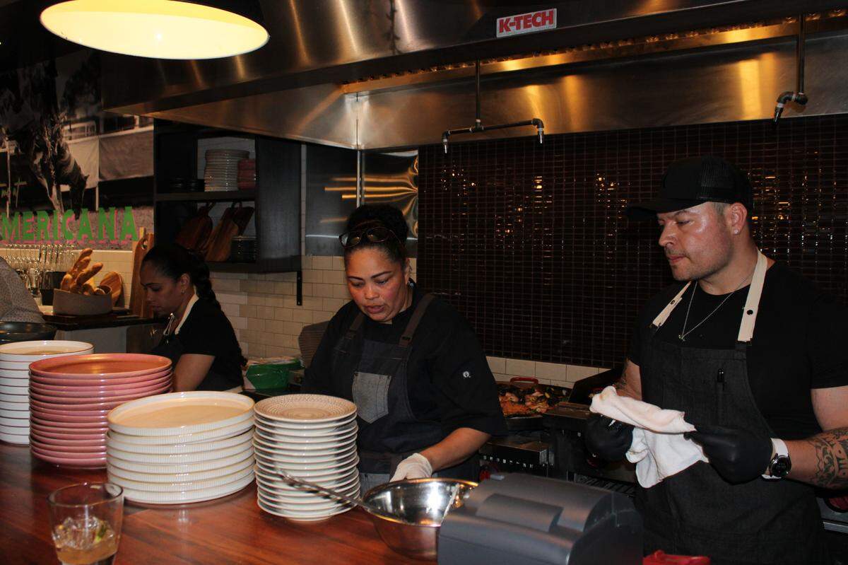 Head Chef at Cafe Americana, Wendy Felix, working the open kitchen. Shrimp paella, her favorite, cooking on the stove behind her.
