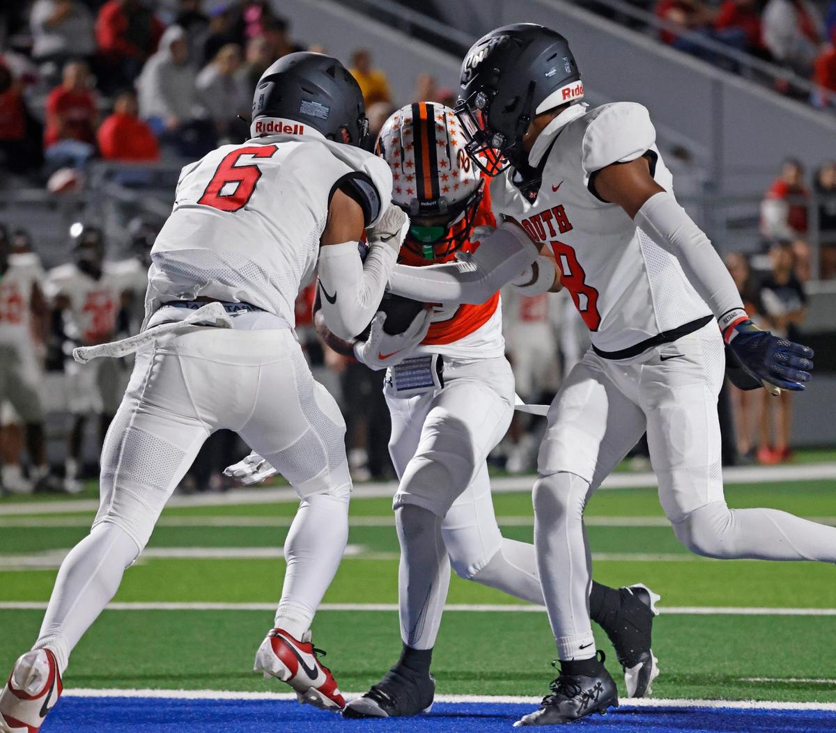 Haltom running back Keenan Jackson (3) pushes South Grand Prairie defensive backs Kayden Henderson (6) and Jameel Ross (8) into the end zone for six during a UIL District 8-6A football game at Birdville Fine Arts/Activity Complex in North Richland Hills, Texas, Thursday, Oct. 31, 2024.