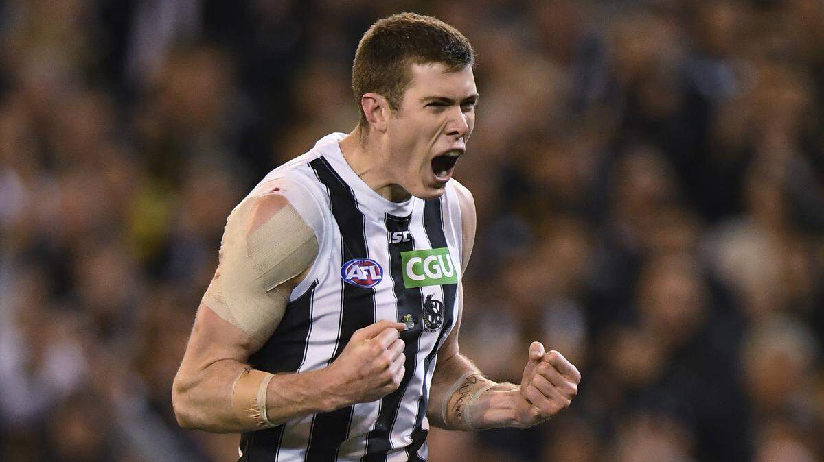 Mason Cox, a 6-foot, 11-inch (2.12-meter) ruckman from Highland Village, Texas, celebrates during the game where he kicks three goals in the second quarter - the first player to achieve that feat at the senior level of Australian Rules football this season - to help the Magpies beat the defending champion Richmond in Melbourne, Australia, Friday, Sept. 21, 2018.