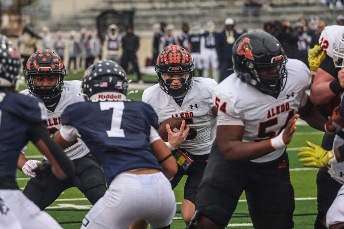 Aledo quarterback Gavin Beard (5) carries the ball into the middle of the line against Denton Ryan in a Class 5A Division 1 state quarterfinal on Saturday, Dec. 7, 2024 at Crowley ISD Multi-Purpose Stadium in Fort Worth, Texas.