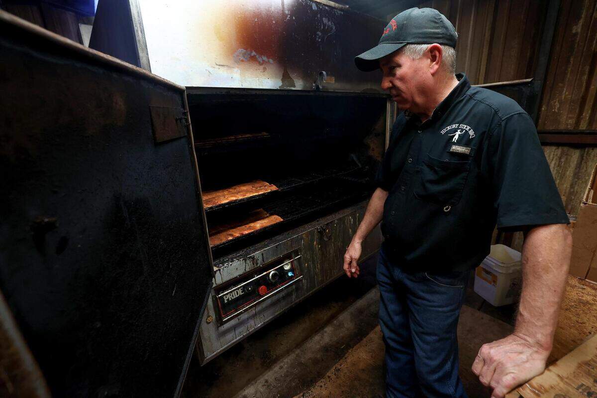 Mark Jones shows one of his smokers cooking brisket, chicken and ribs on June 27 at Hickory Stick Barbecue in Everman.