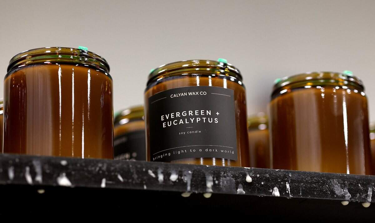 Candles in glass jars wait to set, one of the final steps in the production line at Calyan Candles facility, on Friday, Sept. 12, 2025, in Arlington.