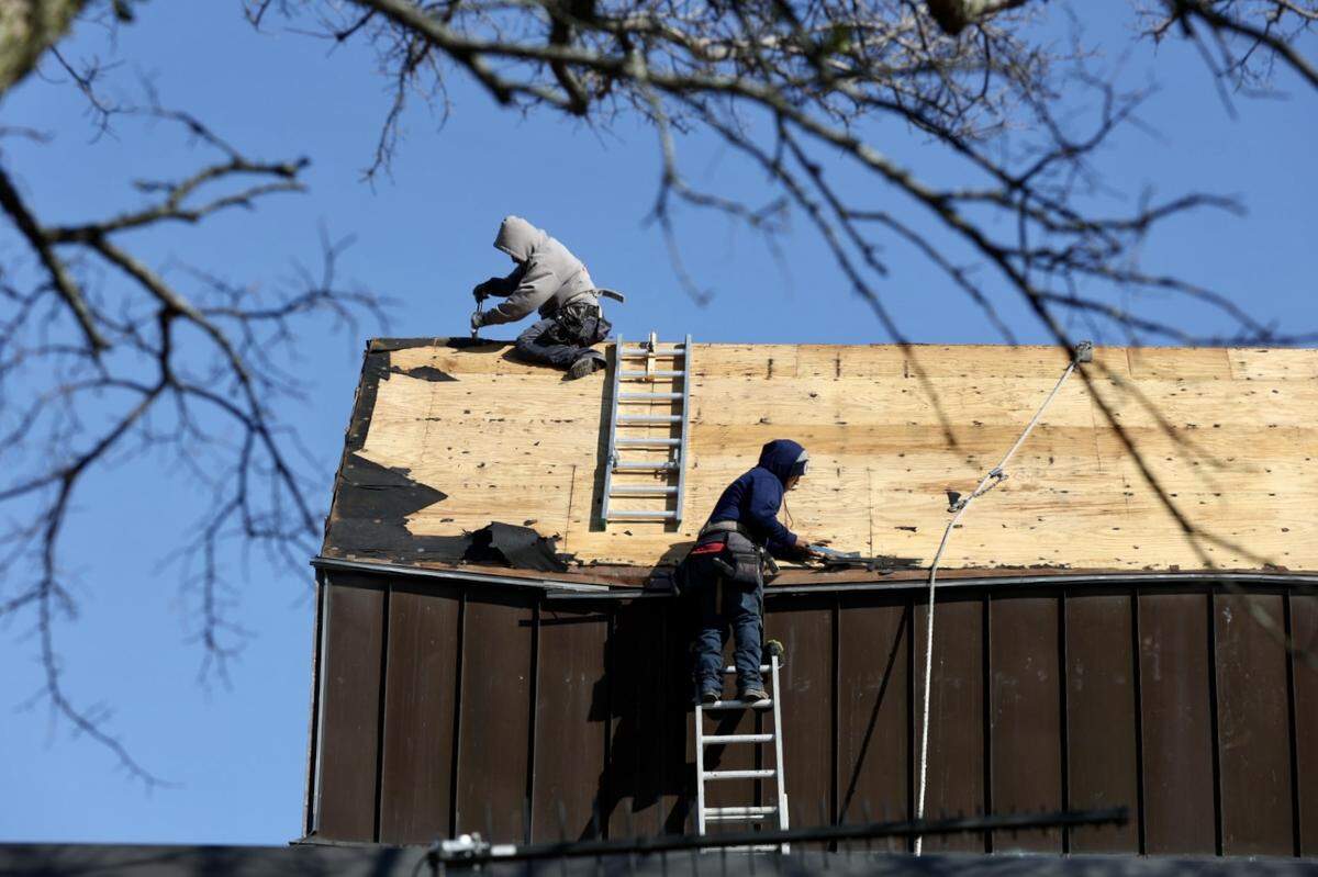 Contractors repair damage to the Weatherford City Hall roof on Friday, the day after severe thunderstorms.