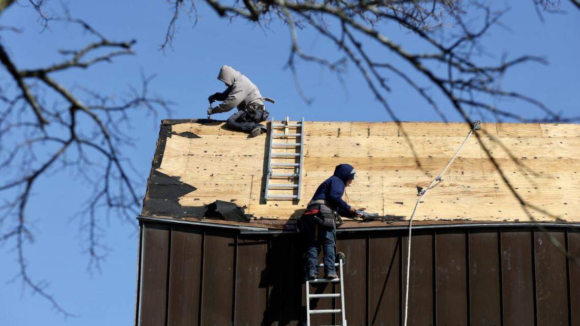Contratistas reparan daños en el techo del Ayuntamiento de Weatherford, al día siguiente de fuertes tormentas eléctricas en Weatherford, Texas, el viernes 3 de marzo de 2023.