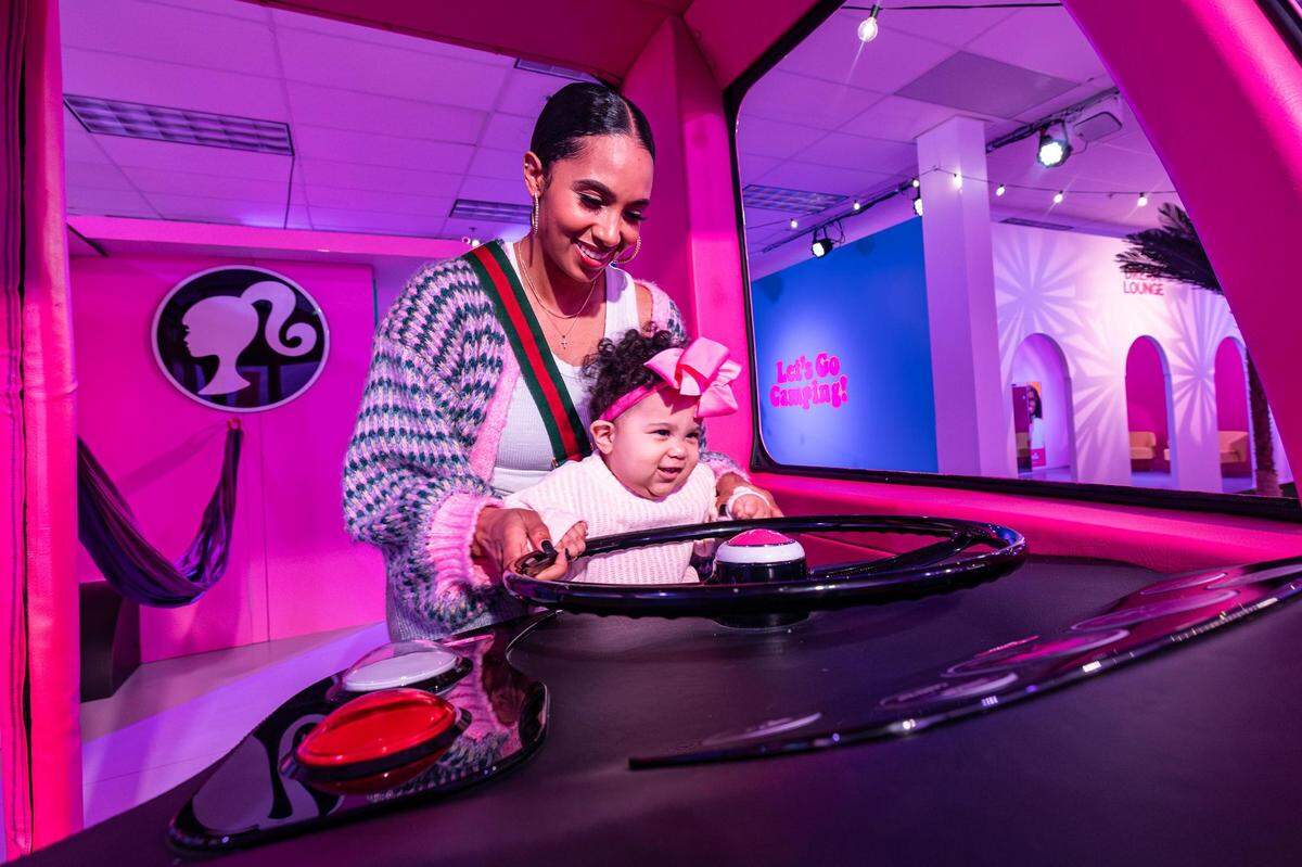 Carrington Franklin-Nakwaasah and her daughter Levi, 10 months, ride in the Barbie Camper at the ‘World of Barbie’ immersive experience at the Stonebriar Centre in Frisco on Thursday, Nov. 16, 2023.