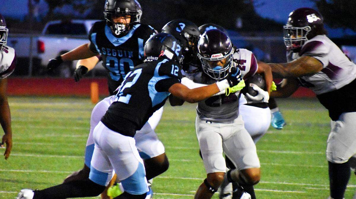 Mansfield Timberview running back Taylor Hanson is wrapped up by Arlington Seguin defensive back Jacob Bly (12) and linebacker Lacorian Hodge (3) during a UIL football game at C.H. Wilemon Field in Arlington on Thursday, Oct. 3, 2024.