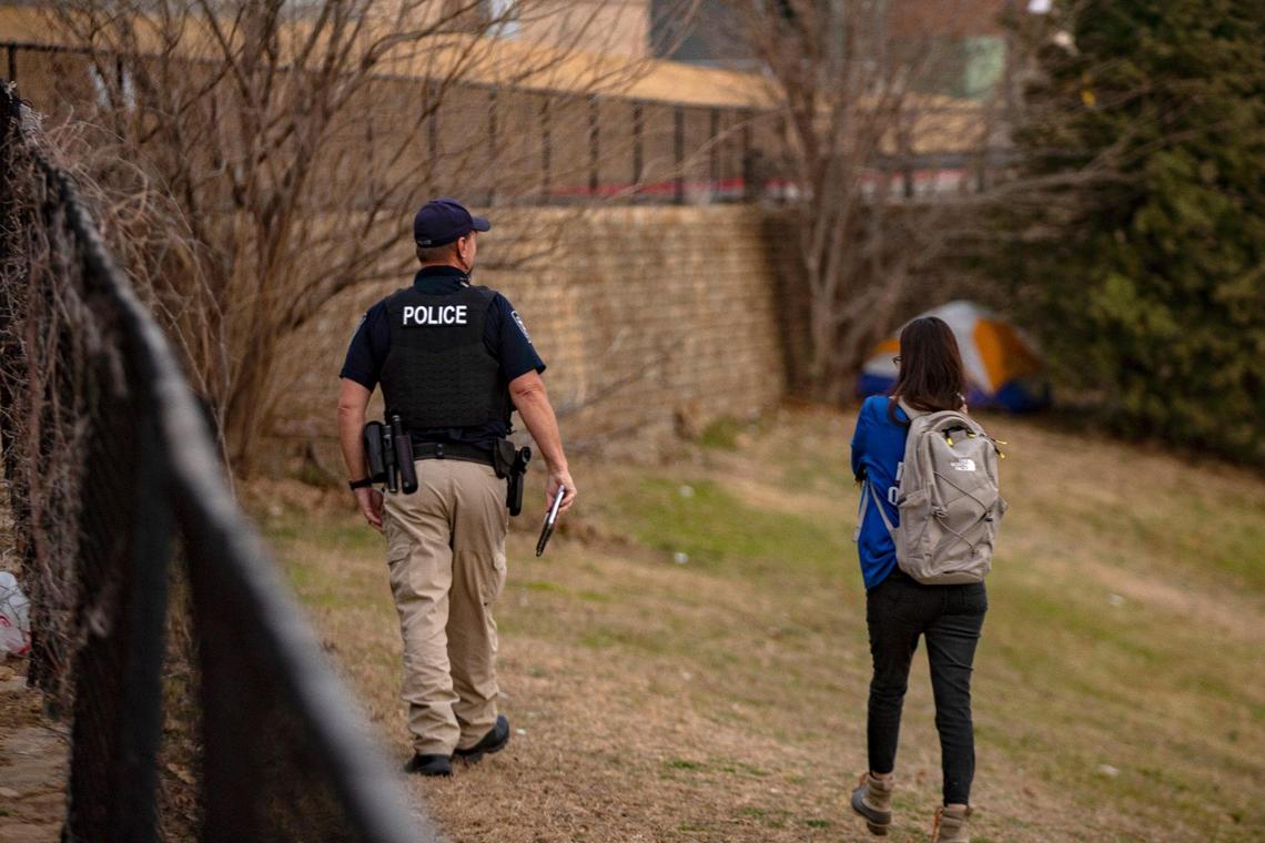 Officer Mike Kuzenka and Day Resource Center mobile assessor Diana Salazar approach a camp set up in Fort Worth on Jan. 18. Kuzenka informs people they’re camping illegally and could be fined, while Salazar provides an assessment to explore avenues for more permanent housing.