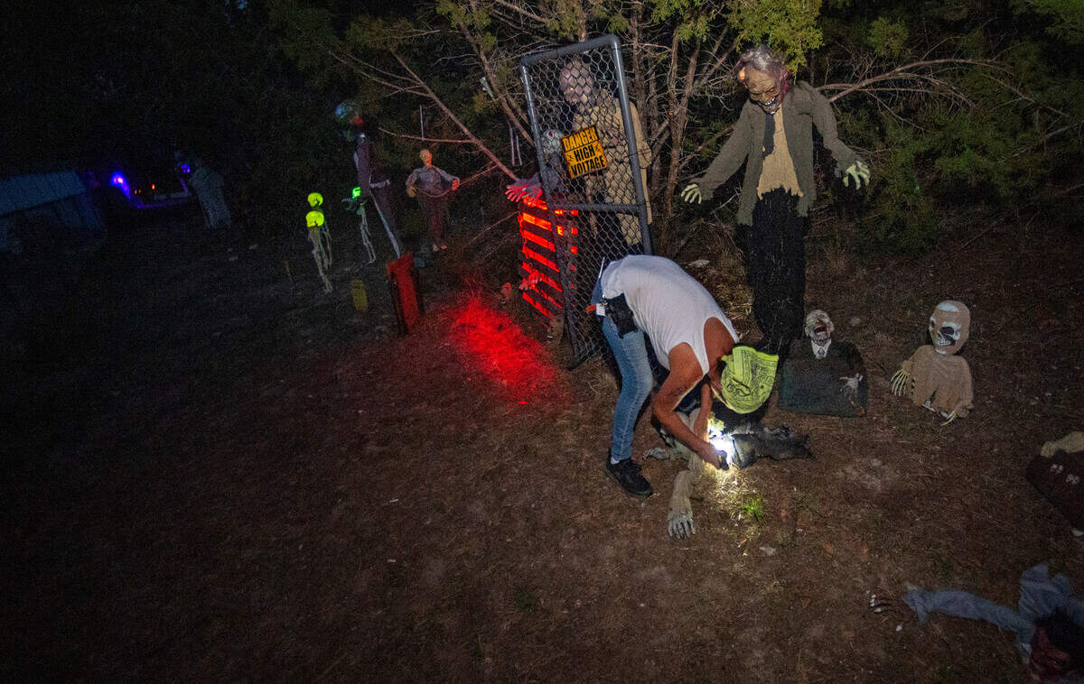 Chris Caughlan makes a final walk-through her “Twisted Crazy Haunt” dsiplays, checking batteries and making sure the animatronics are working properly.
