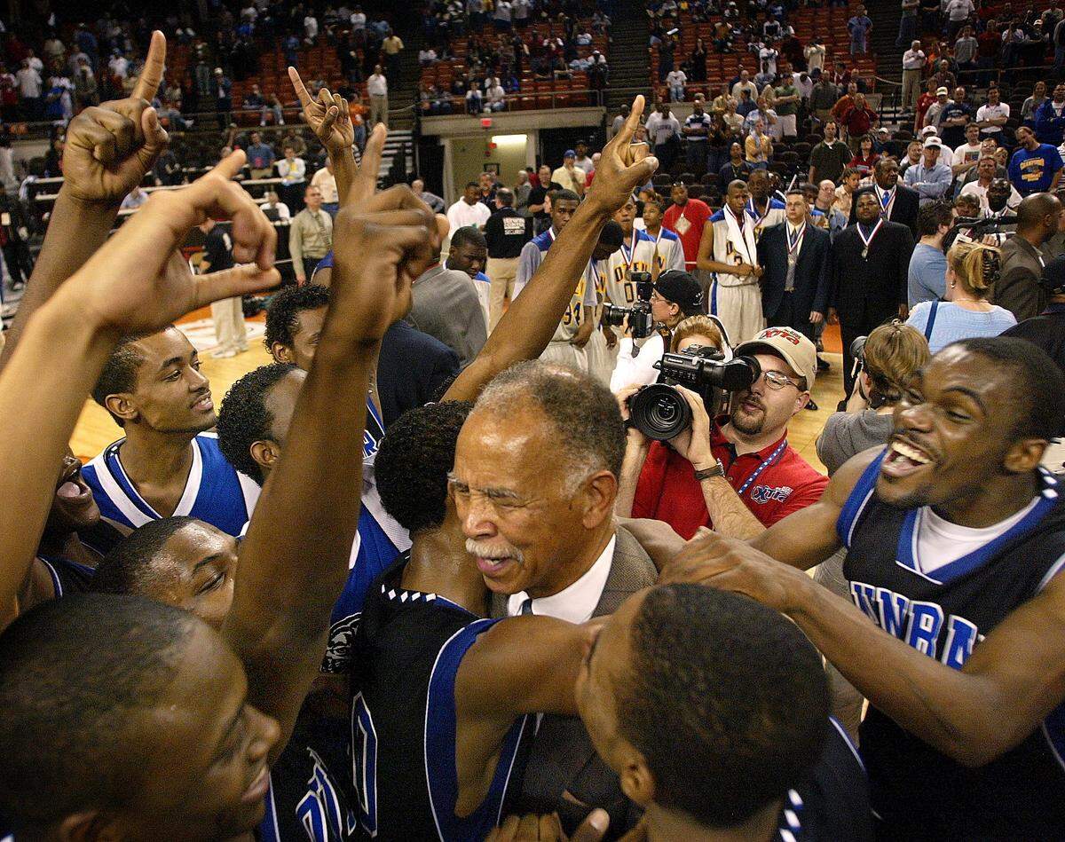 Dunbar head coach Robert Hughes (center) celebrates with his team. At right is Dunbar player Lance Jackson. Dunbar defeats Ozen 66­-54. Conference AAAA Boy’s Basketball State Championship Final at the Frank Erwin Center in Austin,Texas Saturday March 8, 2003.
