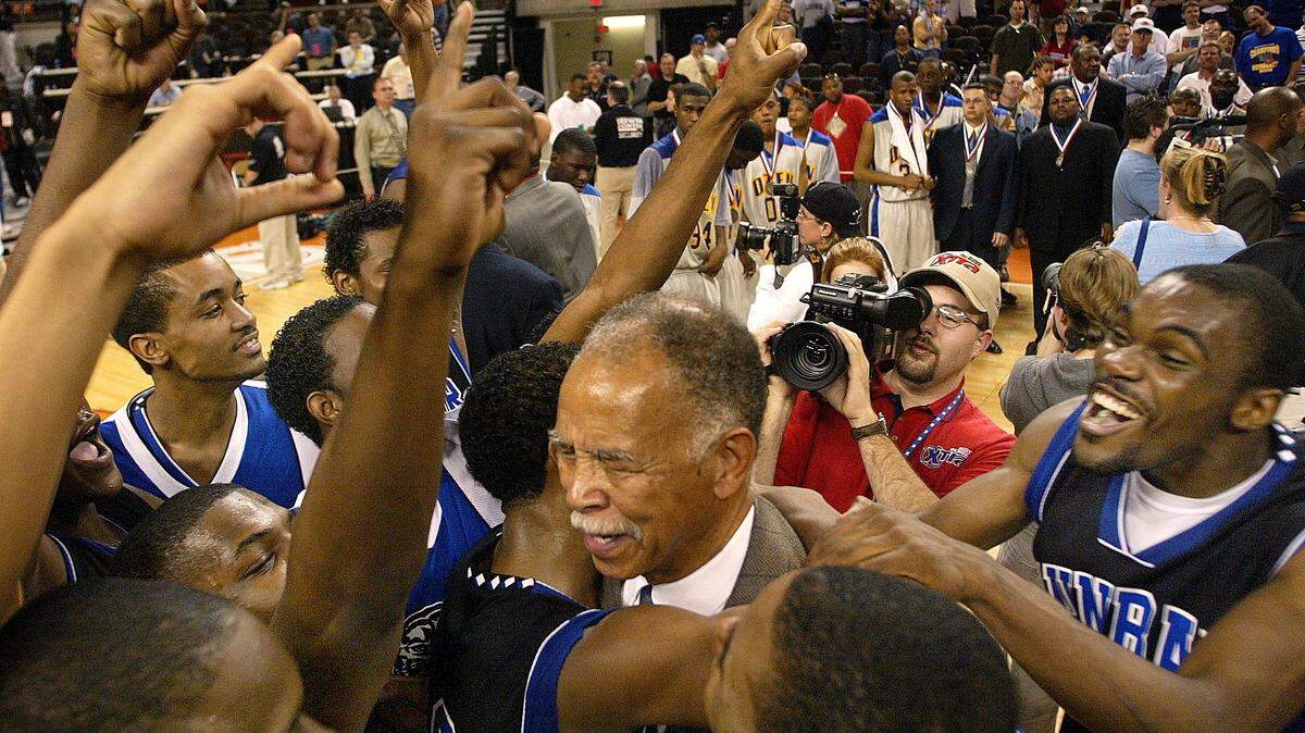 Dunbar head coach Robert Hughes (center) celebrates with his team. At right is Dunbar player Lance Jackson. Dunbar defeats Ozen 66­-54. Conference AAAA Boy’s Basketball State Championship Final at the Frank Erwin Center in Austin,Texas Saturday March 8, 2003.