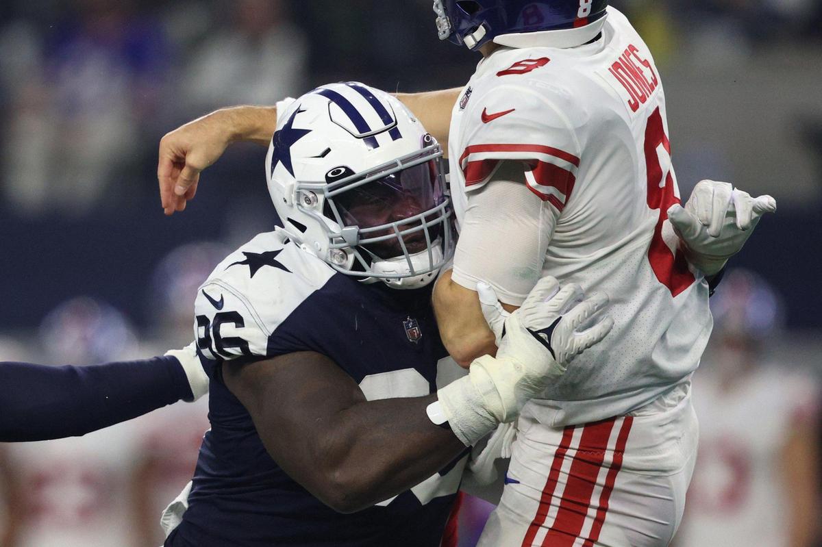Dallas Cowboys tight end Dalton Schultz drives into Giants quarterback Daniel Jones as he passes the ball during their game at the AT&T Stadium in Arlington on Thursday, Nov. 24, 2022.