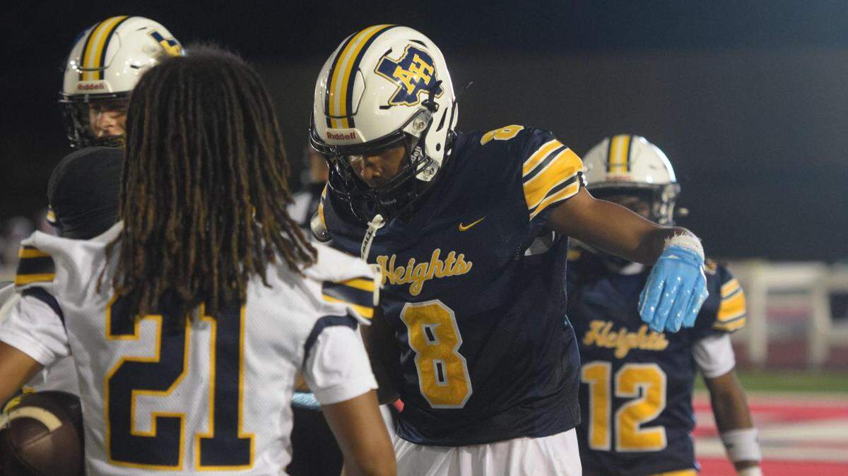 Fort Worth Arlington Heights WR Montez Roberts (8) gives a celebratory handshake to his teammates after scoring a touchdown during a high school football game at Farrington Field in Fort Worth, Texas, Thursday, September 25, 2025. Arlington Heights won 32-14.