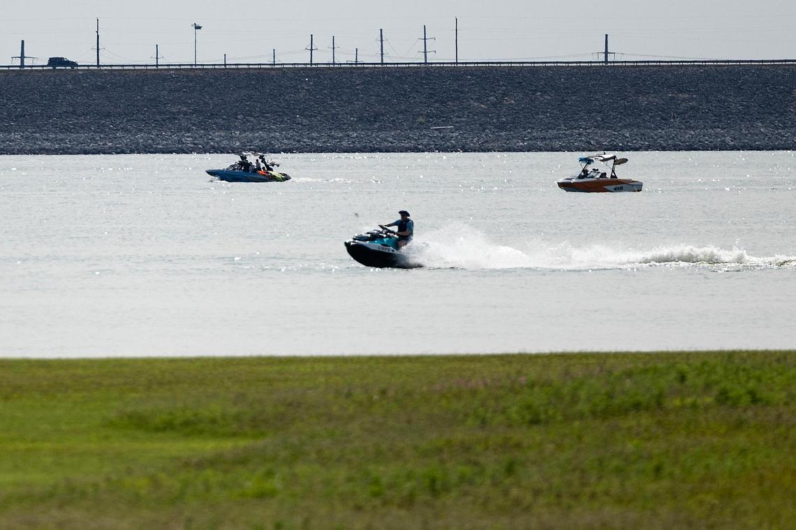 A person on a jet ski rides close to shore at Grapevine Lake near Oak Grove Park on May 31.
