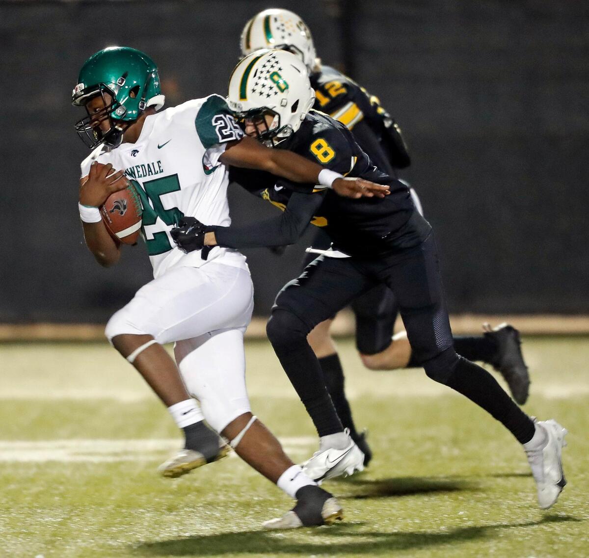 Kennedale running back Jeremiah Clea (25) takes Benbrook defensive backs Eli Guzman (8) and Jake Lindsay (12) downfield for extra yardage in a District 6-4A football game at Handley Field in Fort Worth, Texas, Friday Nov. 05, 2021. Kennedale defeated Benbrook 63-0. (Special to the Star-Telegram Bob Booth)