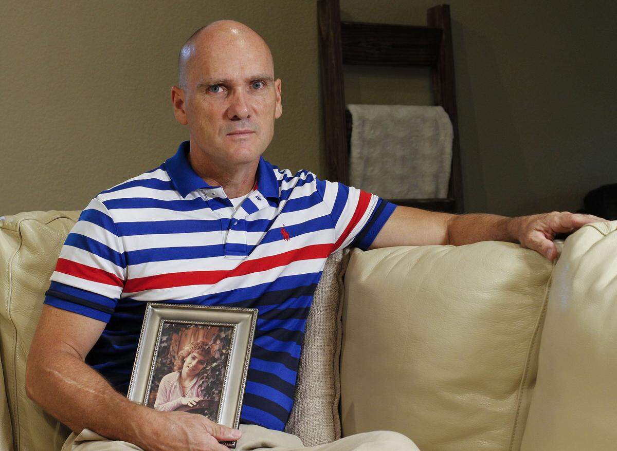 Claudio Branch holds a photo of his sister, Teresa Branch. Teresa was raped and murdered in Arlington in 1986, and the case remains unsolved.