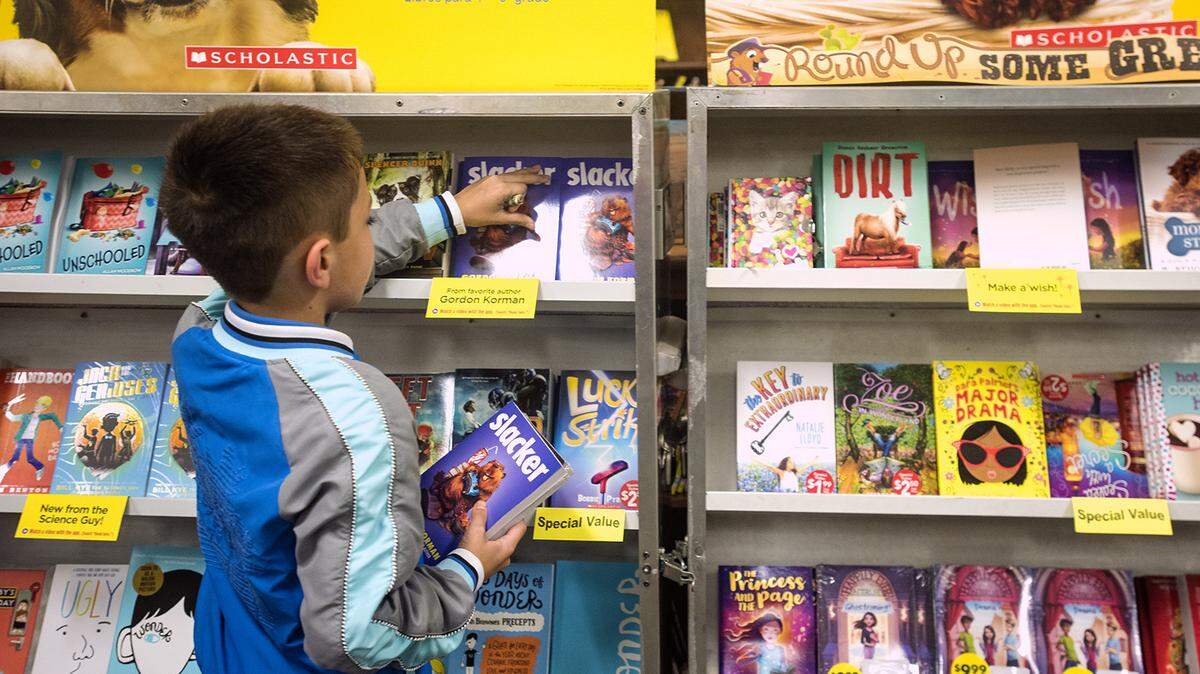In a Sept. 19, 2017 photo, Gabrian McDaniel, 9, picks out a book at a book fair at Dixie Elementary School in Tyler, Texas.
