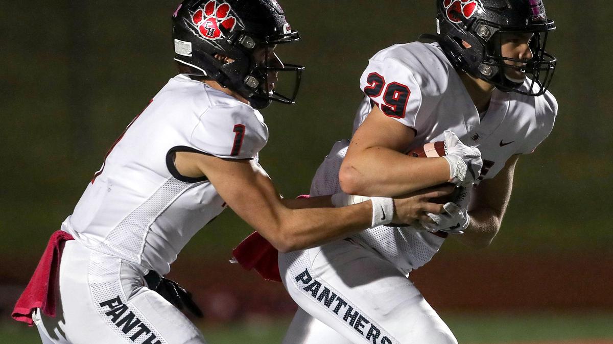 Colleyville Heritage quarterback Mason Murdock (1) hands the ball off to running back Braxton Ash (29) during the first haif, Friday night, October 25, 2019 played at Mustang-Panther Stadium in Grapevine, TX.