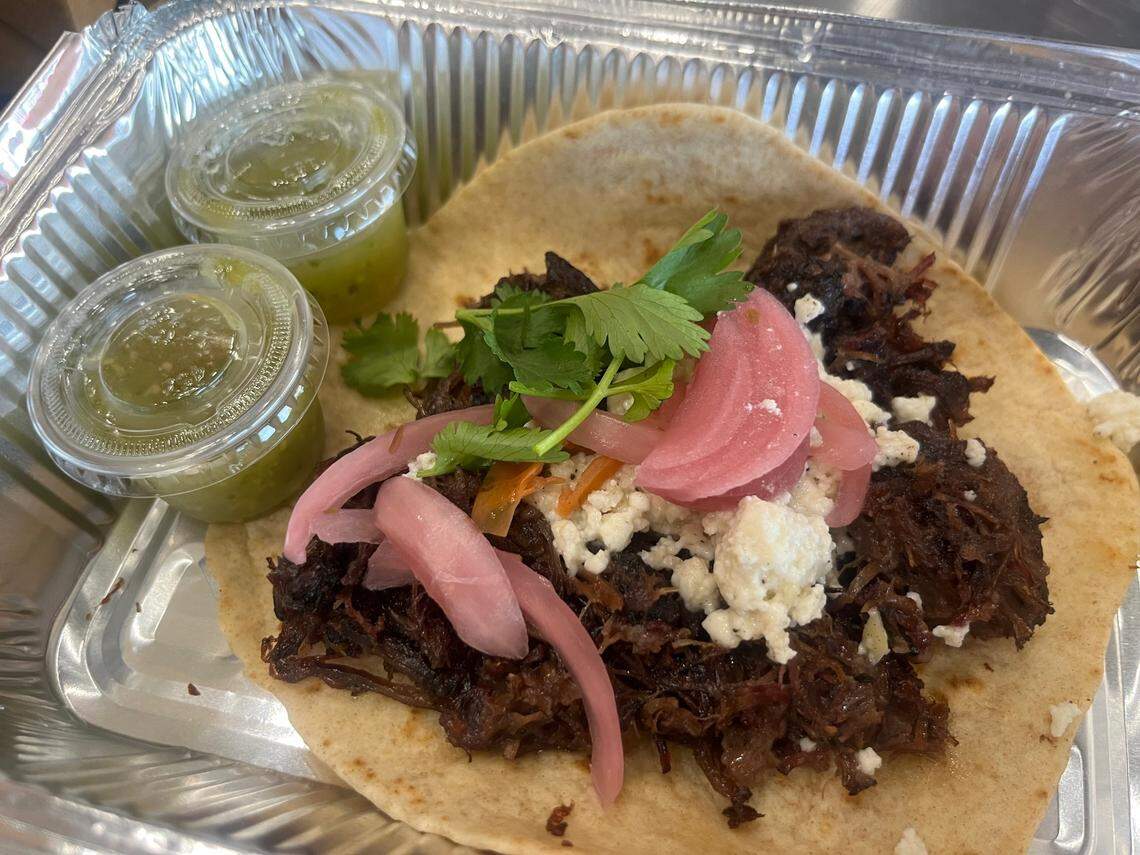 The beef cheek taco at Tacos Y Rocky with a side of salsa verde.