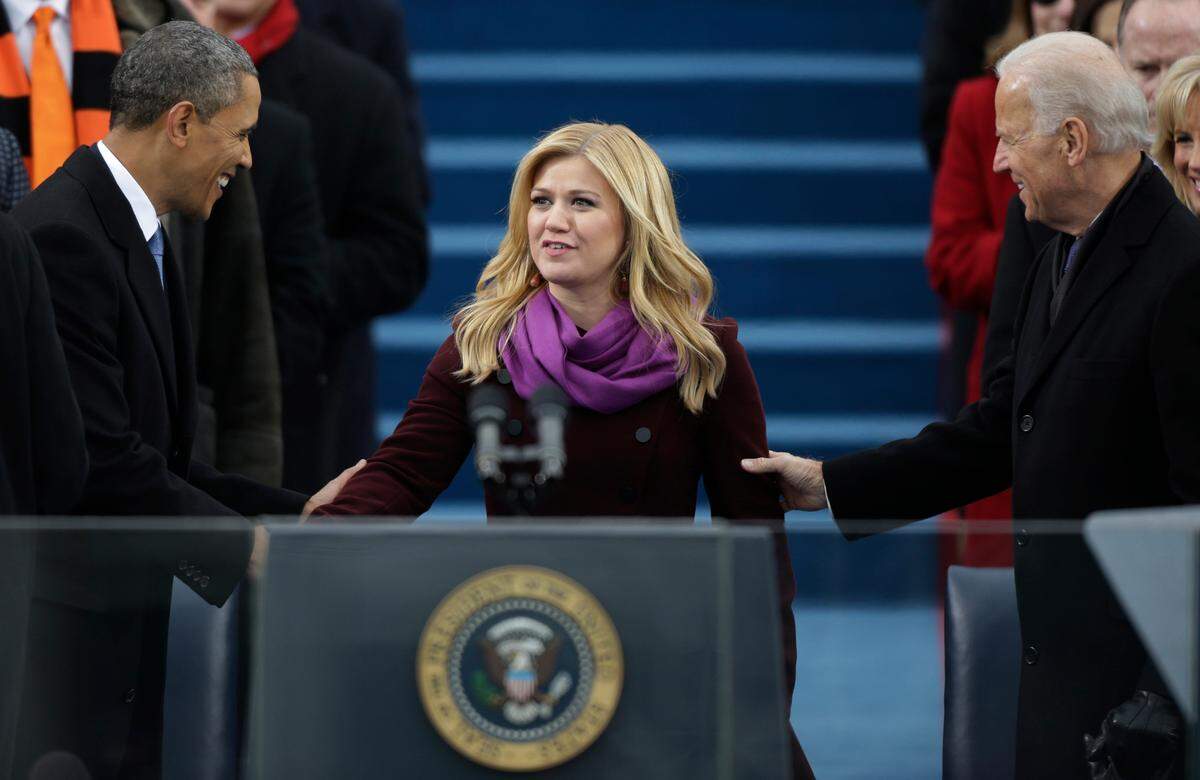 FILE - Singer Kelly Clarkson is greeted by President Barack Obama, left, and Vice President Joe Biden at the ceremonial swearing-in at the U.S. Capitol during the 57th Presidential Inauguration Jan. 21, 2013, in Washington. (AP Photo/Pablo Martinez Monsivais, File)
