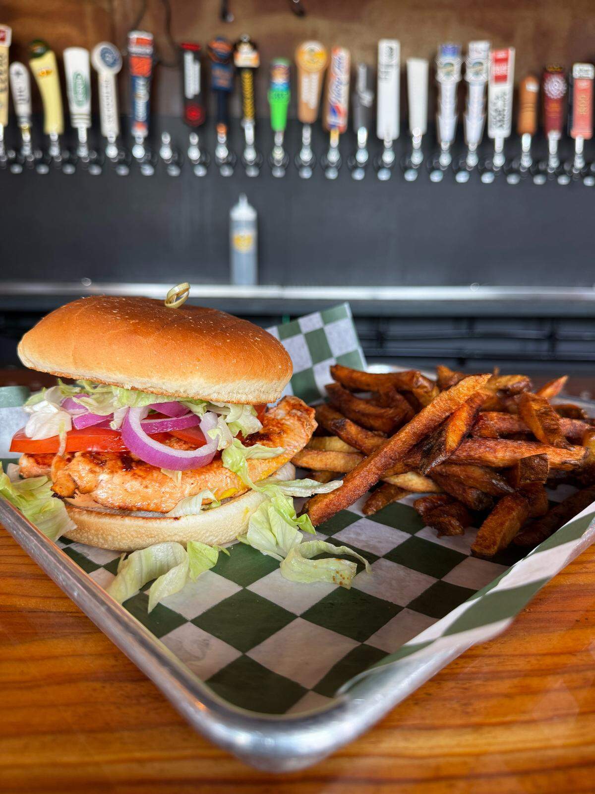 A chicken sandwich with french fries July 27, 2025 at Our Taphouse in Near Southside Fort Worth, Texas.