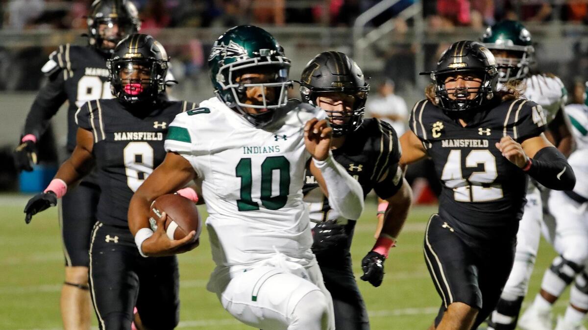 Waxahachie quarterback Roderick Hartsfield Jr. (10) leads the Mansfield defense to the end zone in the first half of a District 11-6A football game at R.L. Anderson Stadium in Mansfield, Texas, Friday, Oct. 21, 2022. Waxahachie led Mansfield 17-3 at the half. (Special to the Star-Telegram Bob Booth)