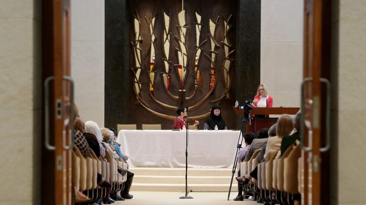 A look down the aisle of a synagogue with a menorah at the end. 