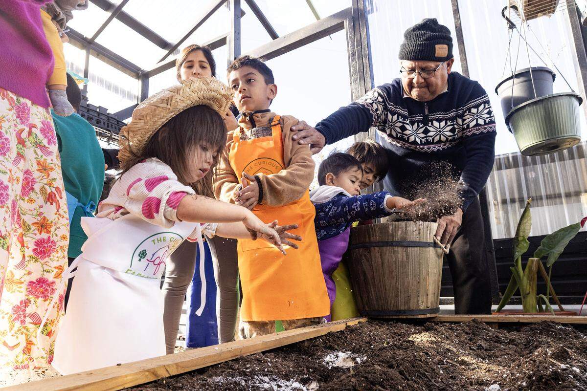 Co-founder Luis Rojas teaches the kids how to plant garlic during class at the Curious Farm House in Godley on Wednesday, Dec. 10, 2025. The Curious Farmhouse is a nature-based, bilingual space where children learn farming, nutrition and hands-on skills through gardening.