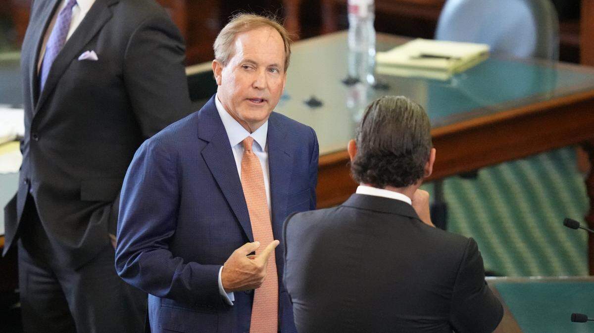 Ken Paxton speaks with lawyer Tony Buzbee on the Senate floor before the start of his impeachment trial on Sept. 5, 2023, at the Capitol in Austin.