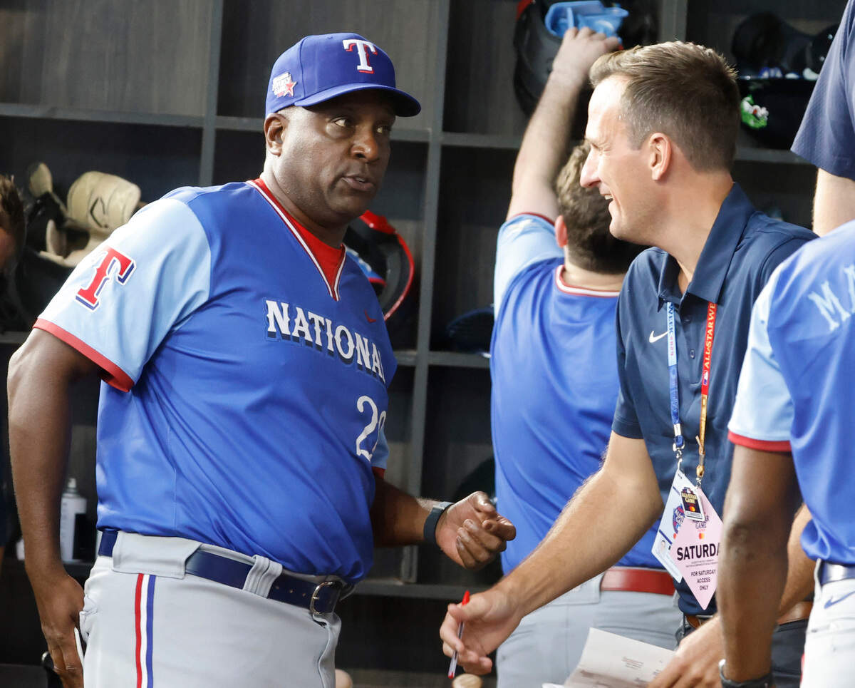 National League first base coach and former Texas Ranger player Darren Oliver talks with a MLB personnel in the dugout during the minor league all-stars Futures Game at Globe Life Field in Arlington, Texas, Saturday July 13, 2024.  