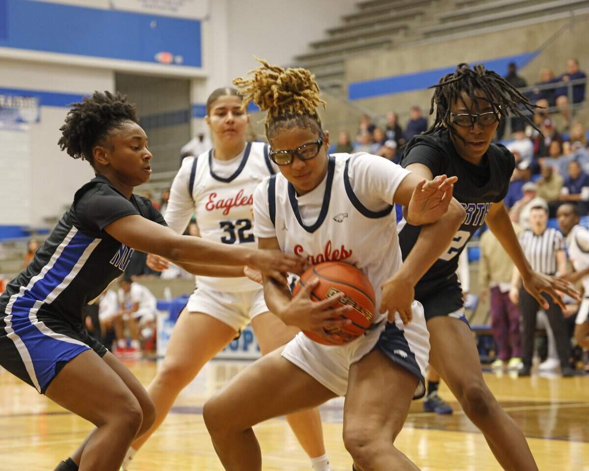 Allen guard Delaney Johnson (23) grabs an offensive rebound between North Crowley guard Eden Johnson (0) and forward Kynnedi Davis (12) during the second half of a UIL Class 6A Division I girls regional semifinals basketball playoff game at Grand Prairie High School in Grand Prairie, Texas, Tuesday Feb. 24, 2026.