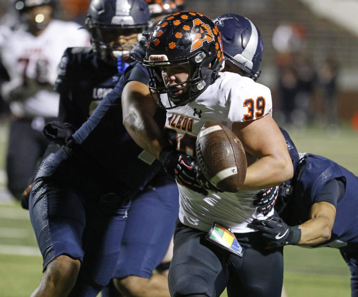 Frisco Lone Star corner back Santonio Martin (5) reaches in and knocks the ball loose from Aledo running back Brady Powell (39) as Powell went out of bounds during the first half of a UIL Class 5A Division I Semifinal on Friday Dec. 12, 2025 at Vernon Newsom Stadium in Mansfield, Texas.