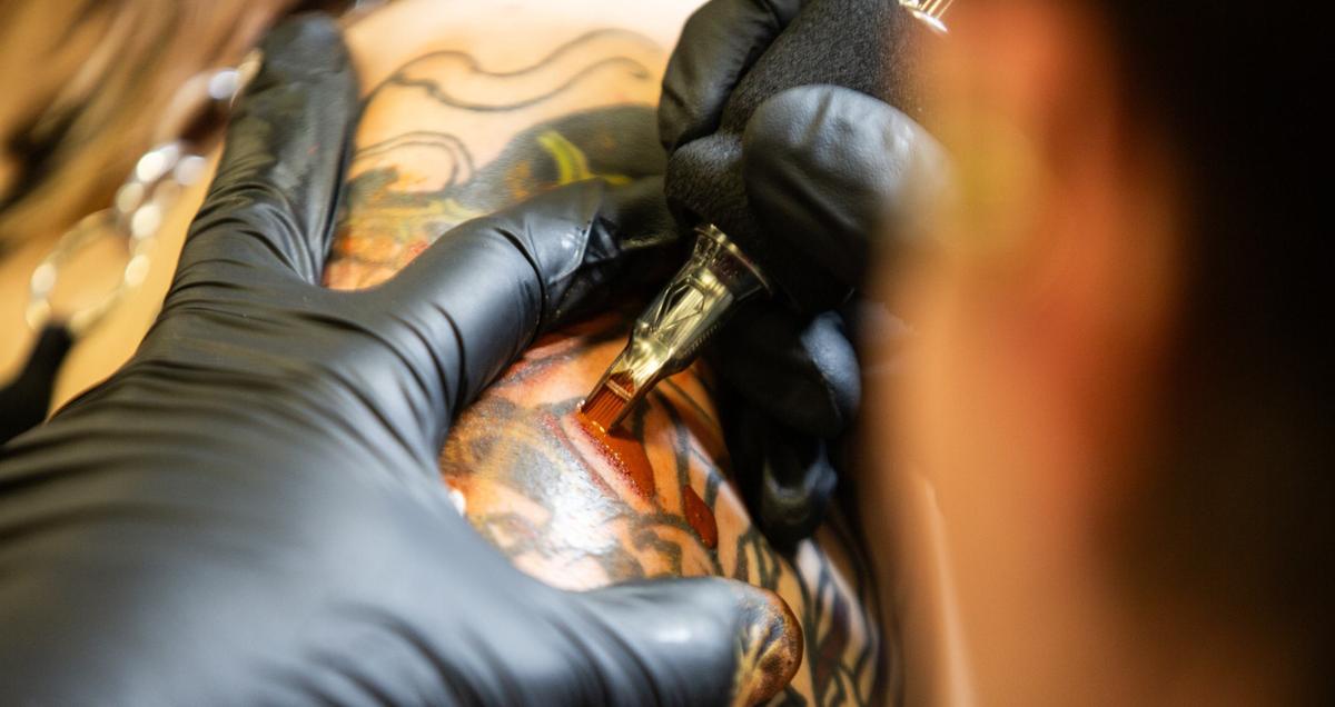A tattoo artist draws a design on a client during Fort Worth Tattoo Arts Festival on Friday, June 7, 2024, at the Fort Worth Convention Center.