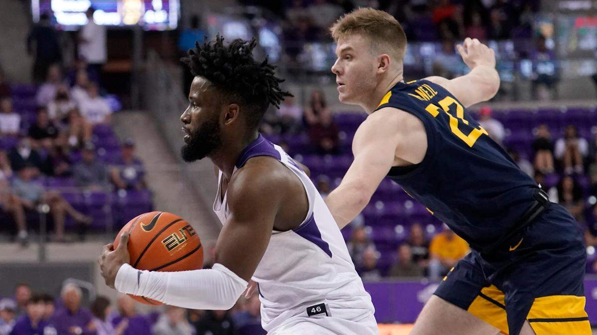 TCU guard Mike Miles, left, moves toward the basket after getting past West Virginia guard Sean McNeil in the second half of Monday’s game.