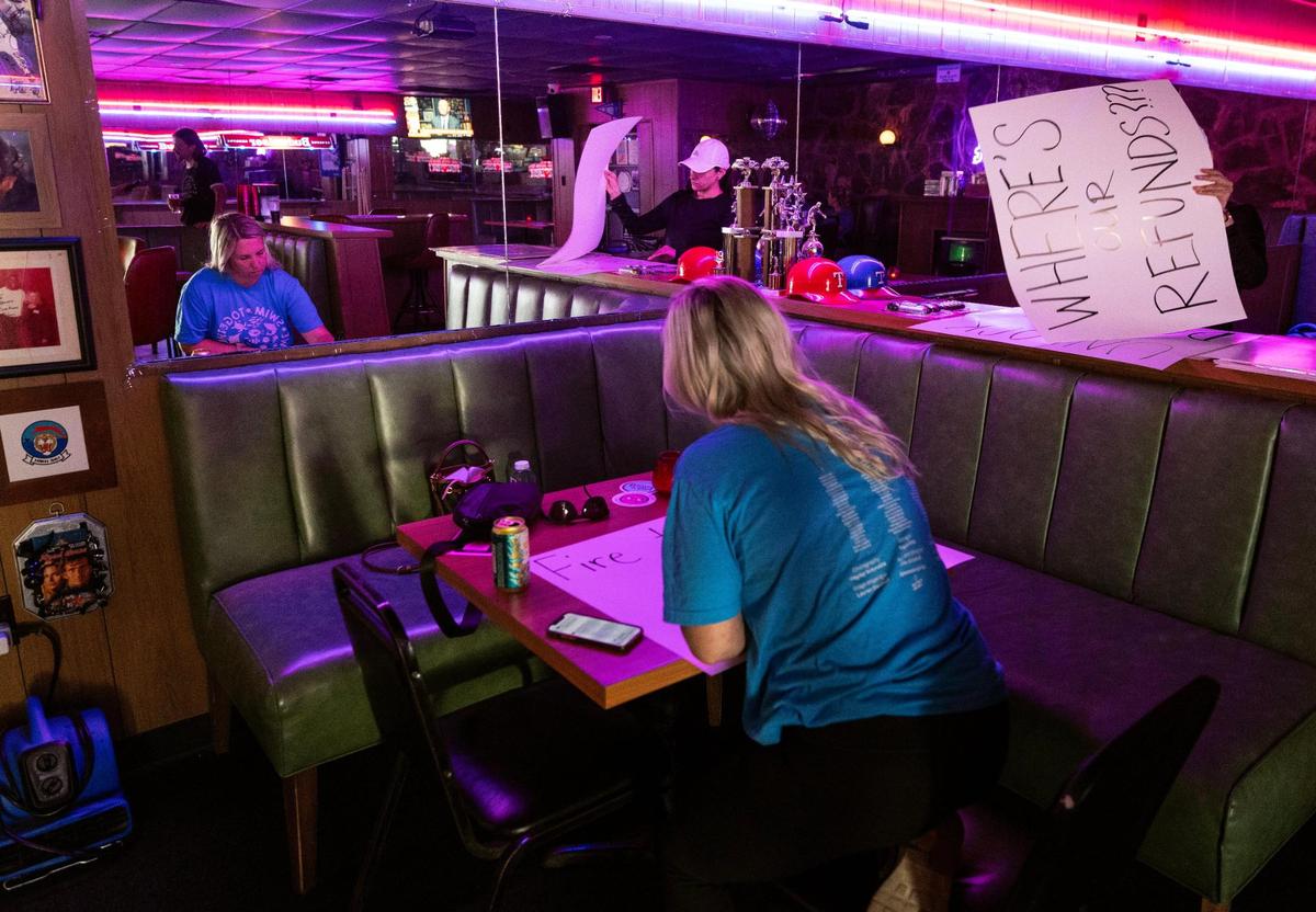 Hayley Schmolze, left, and Lauren Garcia, both residents of The Cooper apartments in Fort Worth, make signs at the Down n’Out bar while preparing to protest the management and owners of The Cooper on Monday, July 7, 2025. Residents say they have had not had adequate communication from the complex following a six-alarm fire that closed the complex two weeks ago.