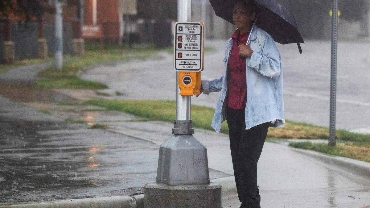 A person waits to cross the road on Jennings Avenue during a heavy rainstorm Monday, Aug. 22, 2022, in Fort Worth.