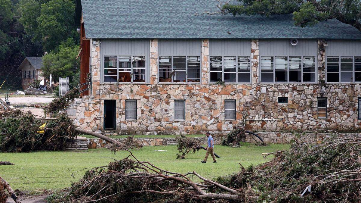 A man walks by a building at Camp Mystic on July 5, 2025, in Hunt, Texas. A flash flood swept through the area, killing more than 100 people.