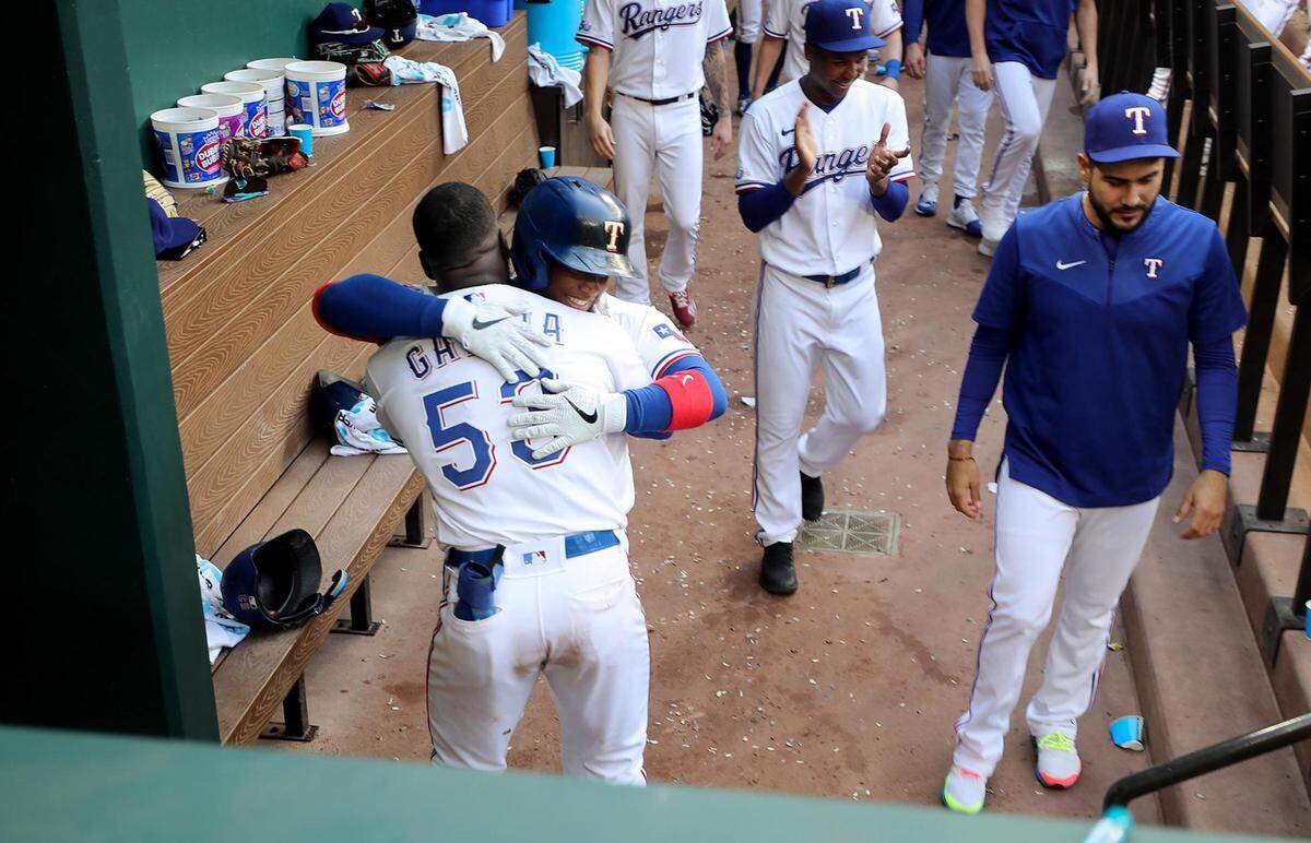 Texas Rangers pinch hitter Willie Calhoun hugs teammate Adolis García after hitting a home run to tie the game in the bottom of the 9th inning against the Colorado Rockies on Monday, April 11, 2022, at Globe Life Field.
