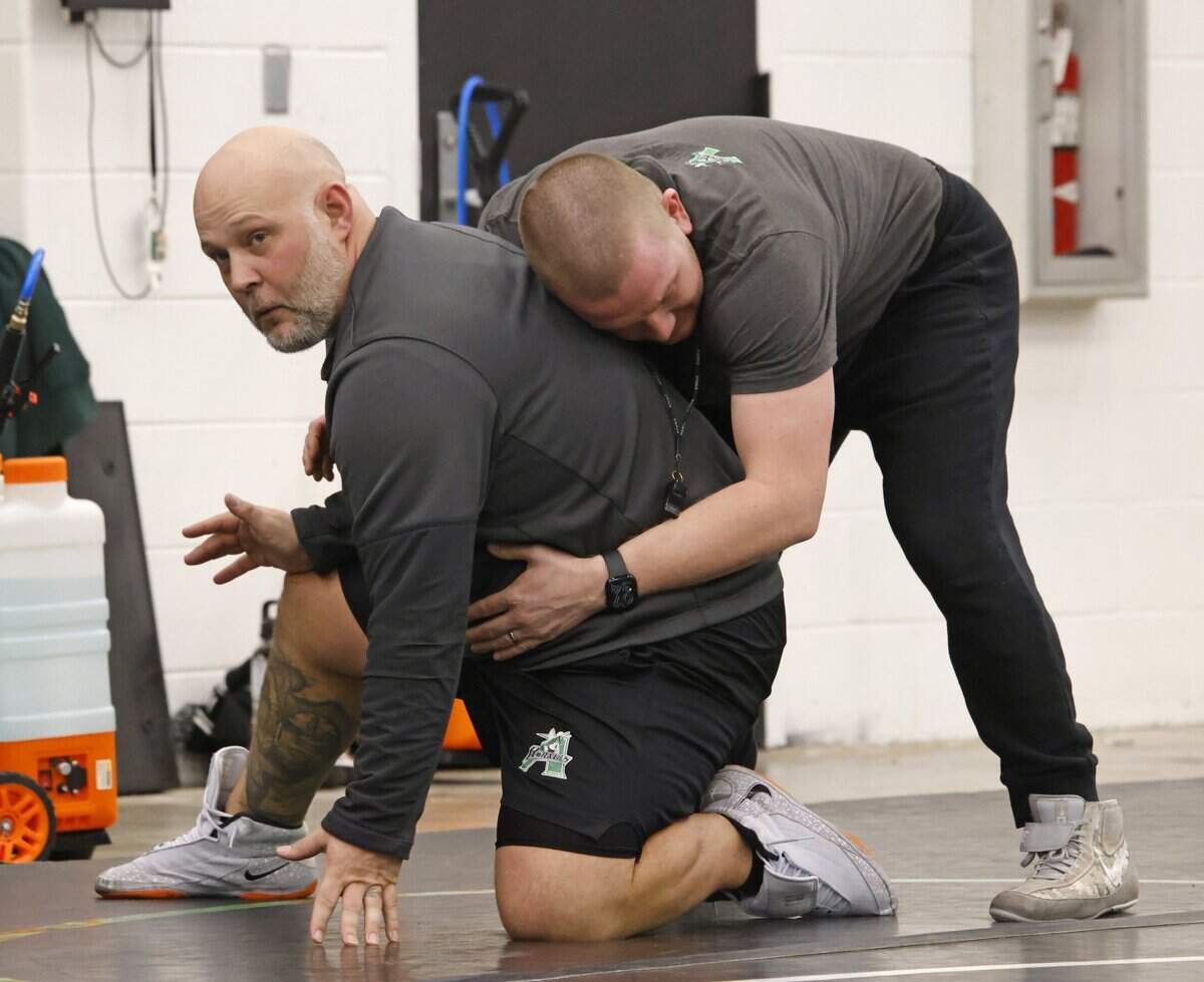 Axle girls head wrestling coach Jayson Conger and boys head coach Tyler Harrison demonstrate holds and releases during one of the final practices before the state championship meet at Azle High School in Azle, Texas, on Friday, Feb. 9, 2026.