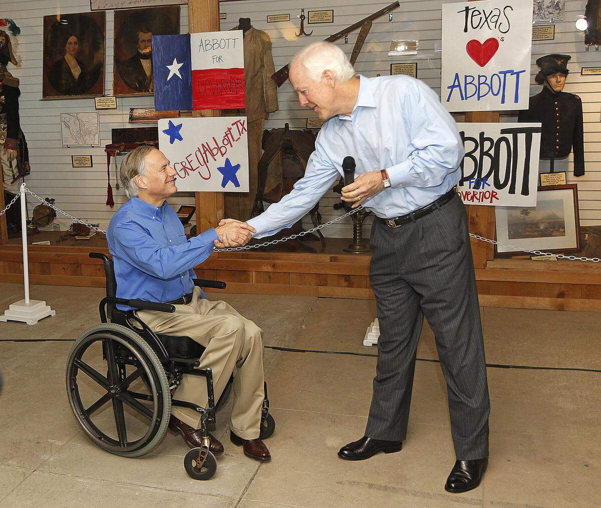 Greg Abbott and John Cornyn shake hands during a political rally in 2014 in Fort Worth. 