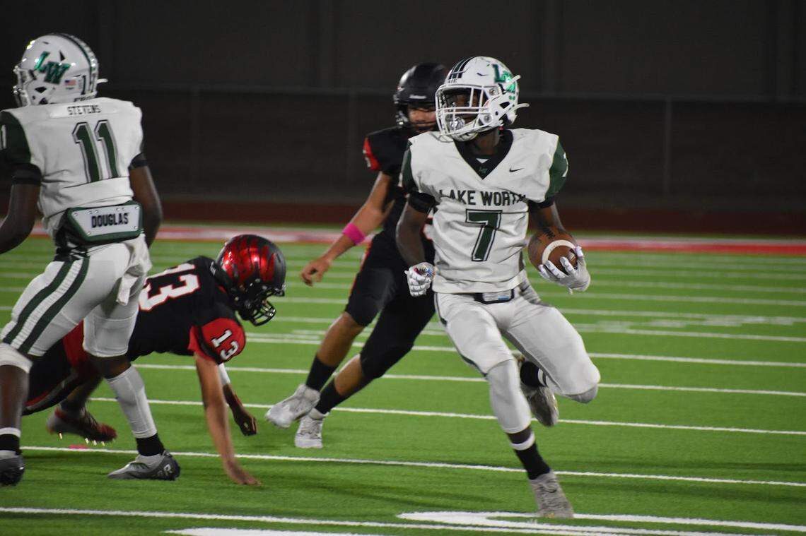 Lake Worth’s Damion Moore (7) dodged Fort Worth Diamond-Hill Jarvis defense, making his second touchdown in the first quarter during a high school football game at Clark Stadium in Fort Worth, Texas, Thursday, Oct. 13, 2022. Lake Worth won 66-0. (Nang Sang/Special to the Star-Telegram)