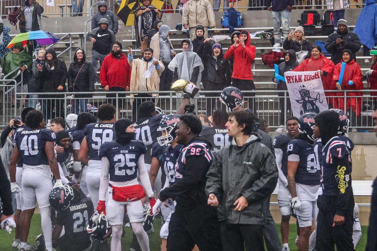 Denton Ryan players raise the regional final trophy and celebrate with fans after defeating Aledo 31-21 in a Class 5A Division 1 state quarterfinal on Saturday, Dec. 7, 2024 at Crowley ISD Multi-Purpose Stadium in Fort Worth, Texas.