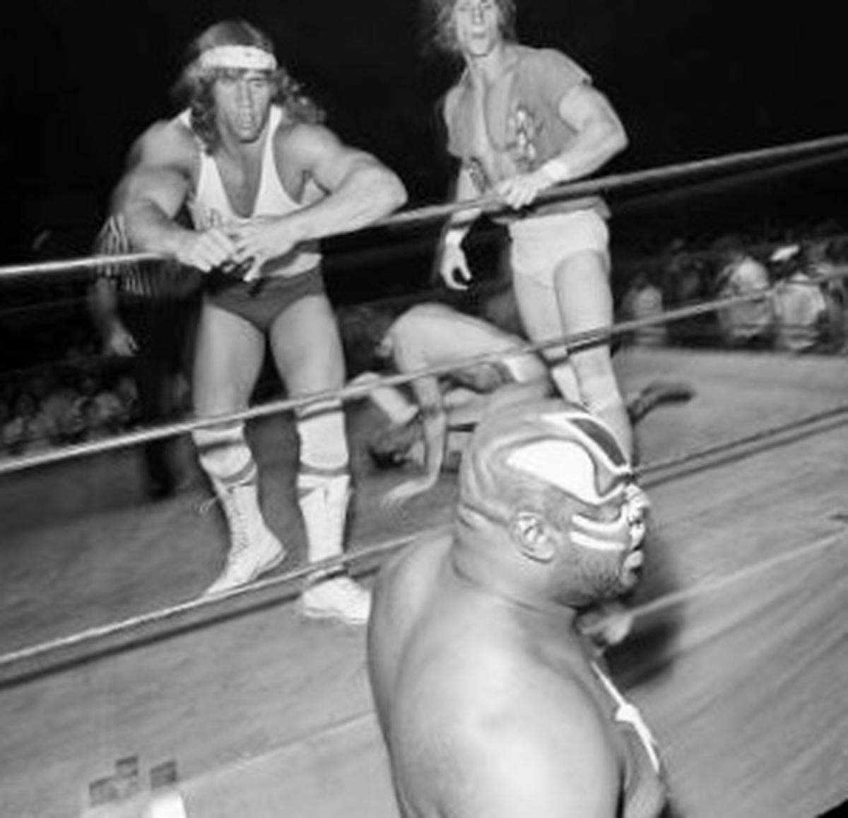 Brothers Kerry and Kevin Von Erich (Kerry Adkisson, Kevin Adkisson) look down at “Kamala the Ugandan Giant” (James Harris) at ringside during wrestling at Will Rogers Coliseum in Fort Worth, about 1983.