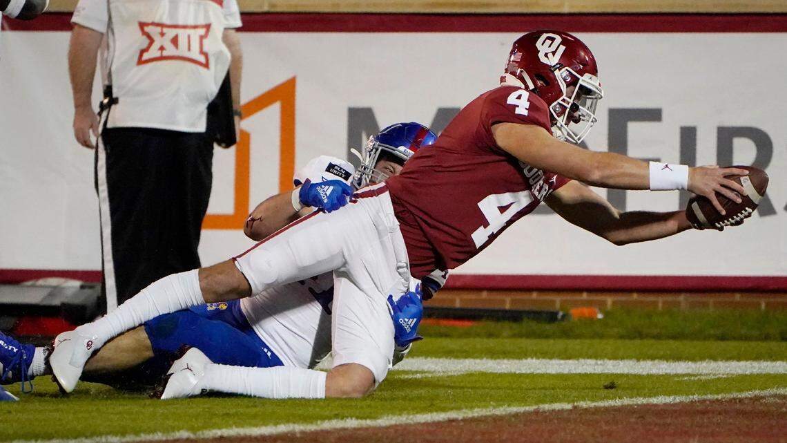 Chandler Morris, diving for a touchdown against Kansas last season, has transferred to TCU but Oklahoma coach Lincoln Riley has yet to release the quarterback from his letter of intent.