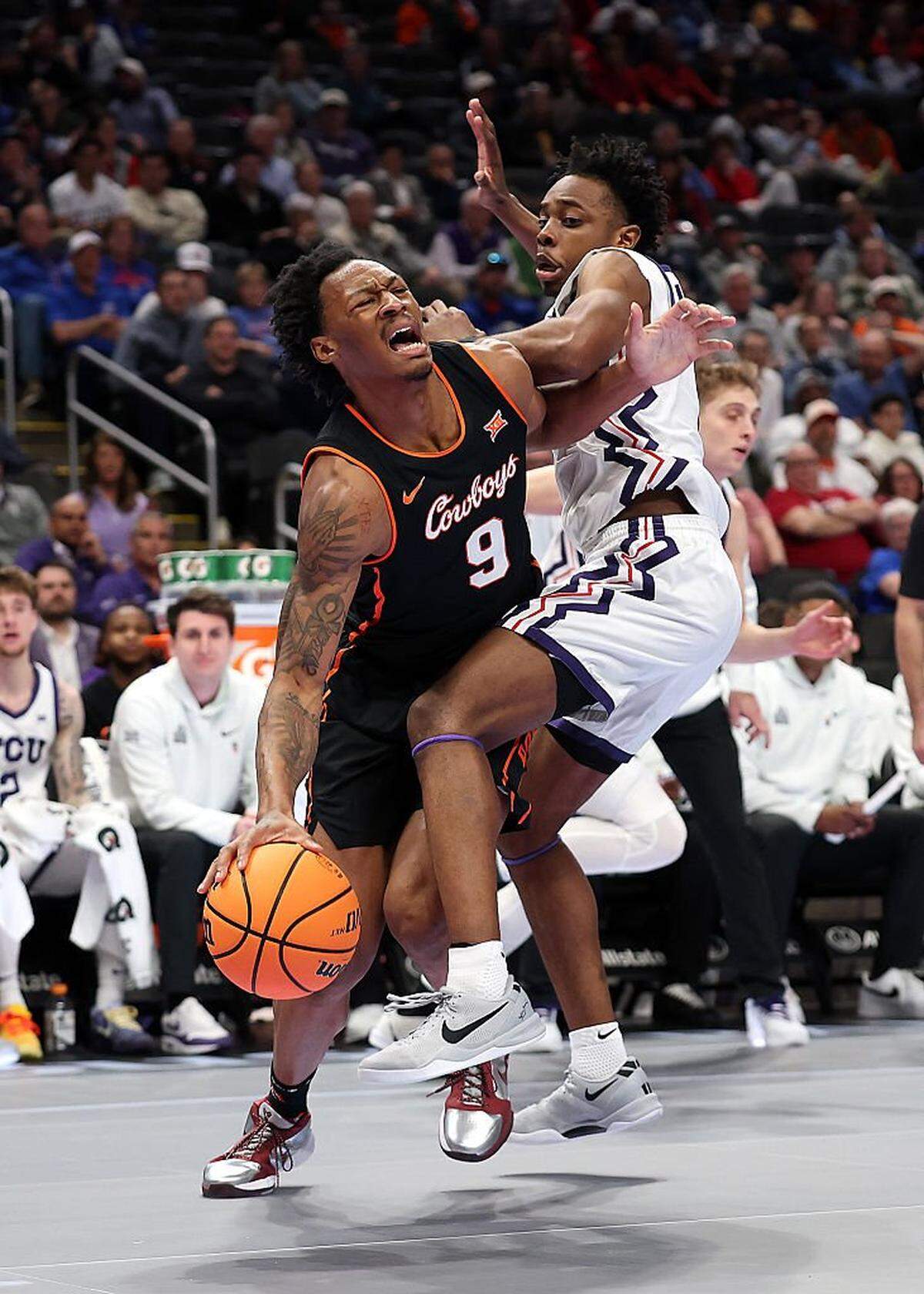 KANSAS CITY, MISSOURI - MARCH 11: Anthony Roy #9 of the Oklahoma State Cowboys is fouled by Jayden Pierre #1 of the Texas Christian University Horned Frogs during the second round game of the Men's 2026 Big 12 Tournament at T-Mobile Center on March 11, 2026 in Kansas City, Missouri. (Photo by Jamie Squire/Getty Images)