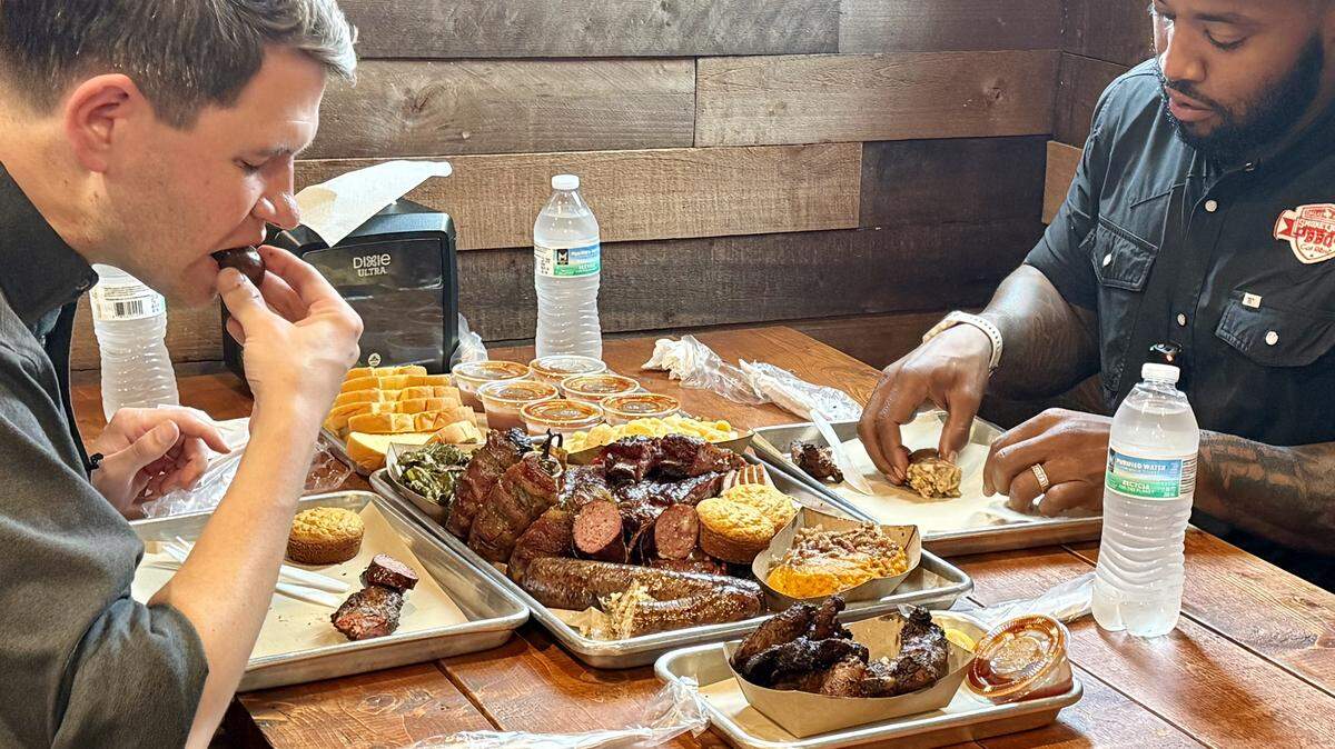 U.S. Senate Democratic candidate James Talarico bites into an East Texas hot link while splitting a meal of Smokey Joe’s BBQ with owner Kris Manning in at the restaurant in South Dallas on June 2, 2026.