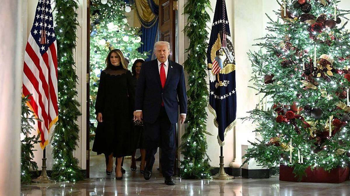 WASHINGTON, DC - DECEMBER 5: President Donald Trump and first lady Melania walk among Christmas decorations en route to the East Room at the White House on December 5, 2025 in Washington, DC. Andrea Bocelli performed a concert in the East Room for the President and first lady. (Photo by John McDonnell/Getty Images)