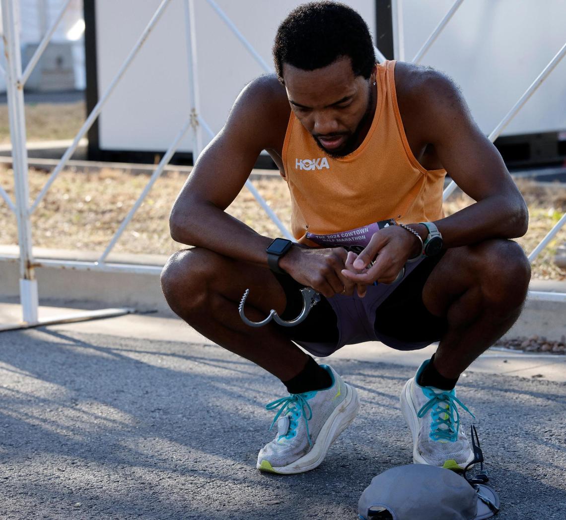 TaMar Hicks removes his handcuffs after completing the 46th annual Cowtown Marathon. He ran the course wearing handcuffs in an effor to set a Guinness World Record.