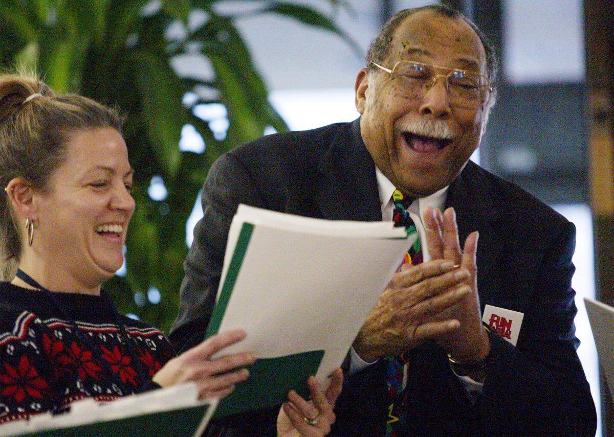 Arlington Mayor Elzie Odom shares a laugh with Carolyn Leenhouts after Odom joined her group in singing Christmas carols at City Hall on Dec. 20, 2002.
